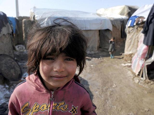 An internally displaced Afghan girl from Helmand province is pictured outside a mud shelter for the displaced at the Charhi Qambar refugee camp on the outskirts of Kabul. Fleeing NATO bombardment and Taliban intimidation, thousands of Afghans in refugee camps in the capital Kabul face a new enemy: an unusually bitter winter that is killing their children. AFP Photo/ Shah Marai