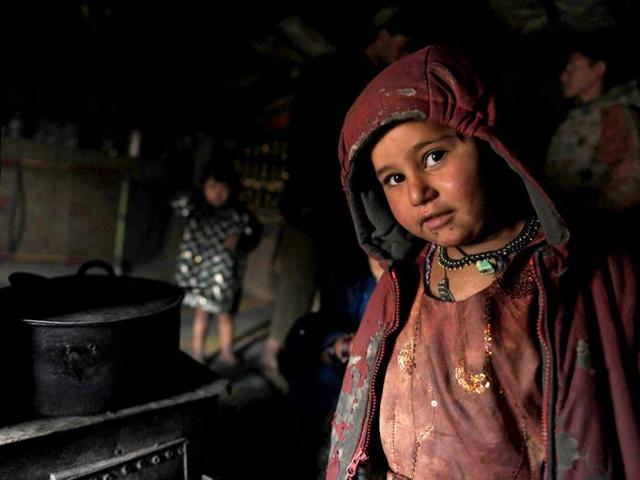 An internally displaced Afghan child from Helmand province poses for a picture inside a mud shelter for the displaced at the Charhi Qambar refugee camp on the outskirts of Kabul. Fleeing NATO bombardment and Taliban intimidation, thousands of Afghans in refugee camps in the capital Kabul face a new enemy: an unusually bitter winter that is killing their children. AFP Photo/ Shah Marai