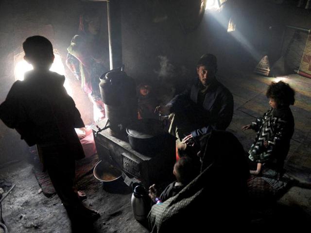 Internally displaced Afghans from Helmand province gather around a heater inside a mud shelter for the displaced at the Charhi Qambar refugee camp on the outskirts of Kabul. Fleeing NATO bombardment and Taliban intimidation, thousands of Afghans in refugee camps in the capital Kabul face a new enemy: an unusually bitter winter that is killing their children. AFP Photo/ Shah Marai