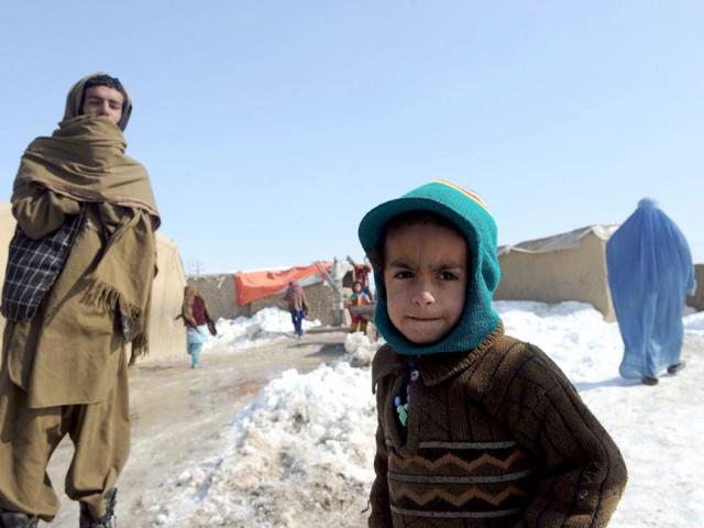 Internally displaced Afghan boys from Helmand province stand outside mud shelters for the displaced at the Charhi Qambar refugee camp on the outskirts of Kabul. Fleeing NATO bombardment and Taliban intimidation, thousands of Afghans in refugee camps in the capital Kabul face a new enemy: an unusually bitter winter that is killing their children. AFP Photo/ Shah Marai