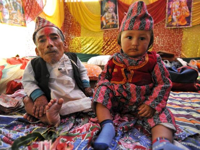 A file picture of Chandra Bahadur Dangi (L), a 72-year-old Nepali who claims to be the world's shortest man at 56 centimetres (22 inches) in height sits next to a child in Jhapa district, southeastern Nepal. AFP Photo/Prakash Mathema