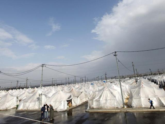 Syrian refugees walk and stand next to their tents at the Boynuyogun refugee camp on the Turkish-Syrian border in Hatay province. Reuters Photo/Murad Sezer