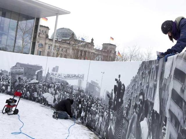 Workers prepare the open-air exhibition "Egypt reloaded" showing a panoramic picture of protestors in Cairo's Tahrir square in front of the Reichstag building, which houses the German parliament Bundestag in Berlin, Germany. AP Photo/Gero Breloer