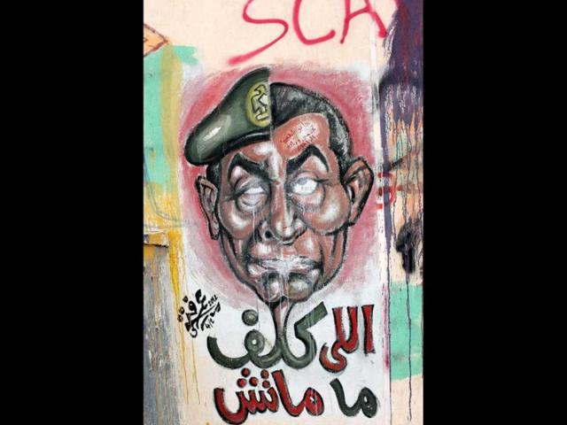 A mural depicting military ruler Field Marshal Hussein Tantawi on the left side of the face and and ousted president Mubarak (R) and Arabic that reads, "who assigned you did not die," in Cairo, Egypt. AP Photo/Nasser Nasser
