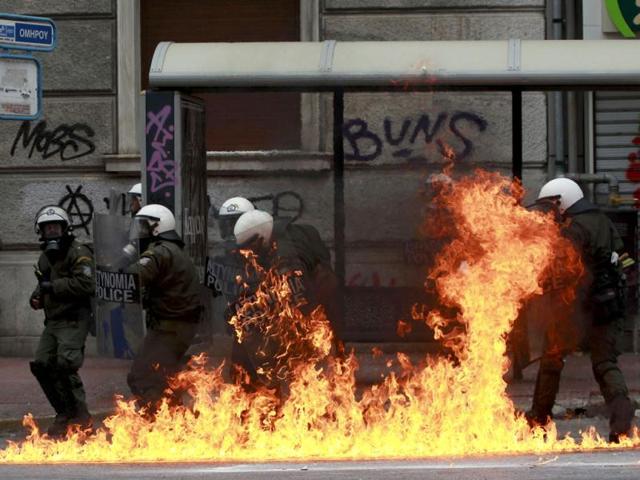 A petrol bomb explodes near riot police during protests against planned reforms by Greece's coalition government in Athens. REUTERS/John Kolesidis