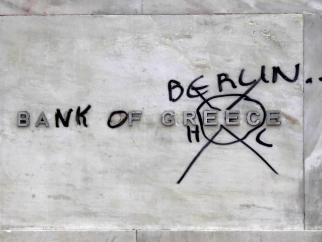 A defaced Bank of Greece sign is seen during protests against planned reforms by Greece's coalition government in Athens. REUTERS/John Kolesidis