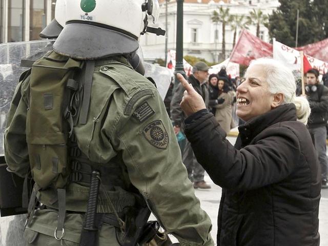 A demonstrator confronts riot police during protests against planned reforms by Greece's coalition government in Athens. REUTERS/Yiorgos Karahalis