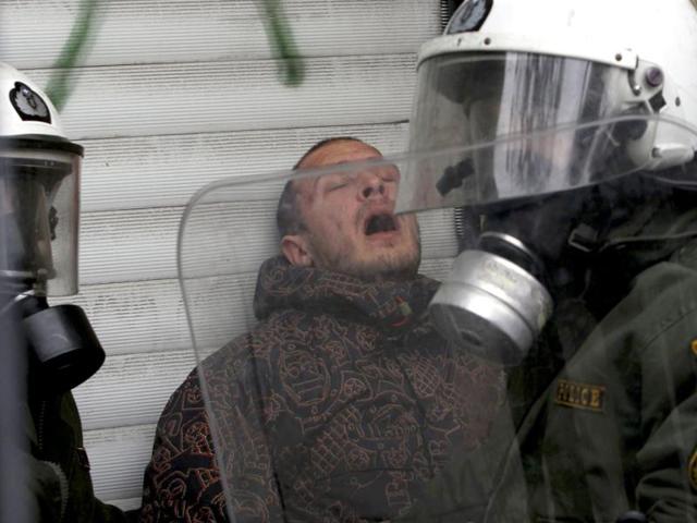 A demonstrator is detained by riot police during protests against planned reforms by Greece's coalition government in Athens. REUTERS/John Kolesidis