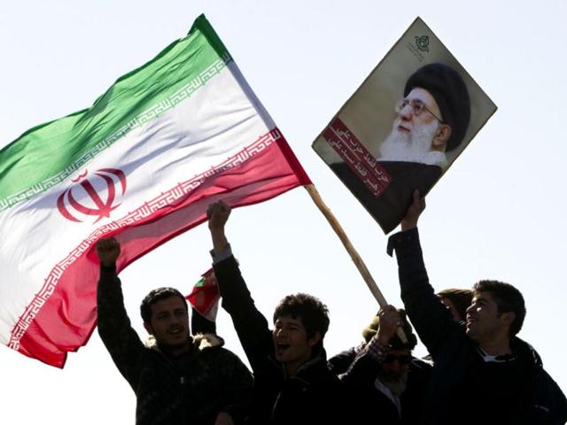 Demonstrators wave Iran's flag and hold up a picture of supreme leader Ayatollah Ali Khamenei during a ceremony to mark the 33rd anniversary of the Islamic Revolution, in Tehran's Azadi square. Iran's President Mahmoud Ahmadinejad said on the anniversary of the revolution that the Islamic Republic would soon announce "very important" achievements in the nuclear field, state TV reported. Reuters/Raheb Homavandi