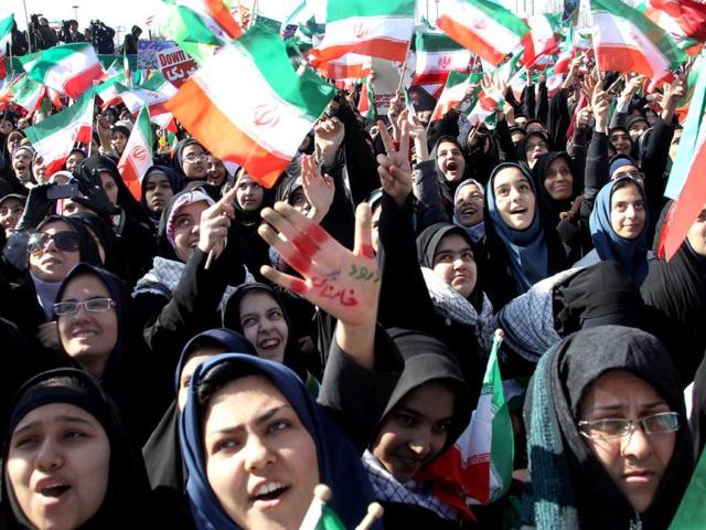 Iranian women wave national flags during a rally to mark the 33rd anniversary of the Islamic revolution in Azadi (Freedom) square in Tehran. Iranian President Mahmoud Ahmadinejad said that Iran has broken the "idol" of the Holocaust underpinning the creation of the Israeli state and US hegemony. AFP Photo/Atta Kenare