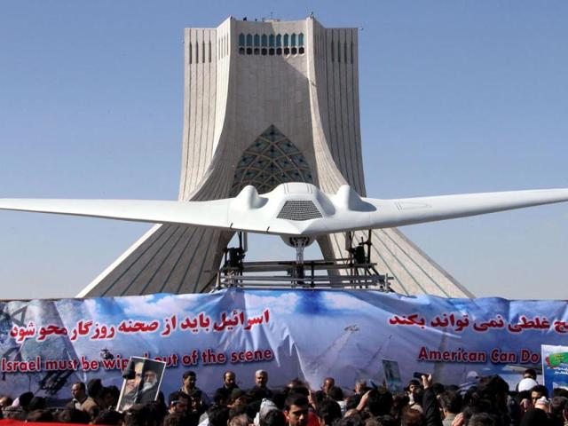 Iranians walk past a replica of the captured US RQ-170 drone which is on display next to the Azadi (Freedom) tower during the 33rd anniversary of the Islamic revolution in Tehran. Iranian President Mahmoud Ahmadinejad said that Iran has broken the "idol" of the Holocaust underpinning the creation of the Israeli state and US hegemony. AFP Photo/Atta Kenare