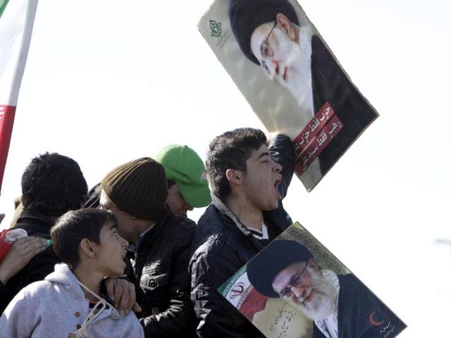 An Iranian youth chants slogans as he holds posters depicting supreme leader Ayatollah Ali Khamenei, at a rally to mark the the 33rd anniversary of the Islamic Revolution that toppled the country's pro-Western monarchy and brought Islamic clerics to power, Tehran. AP Photo/Vahid Salemi