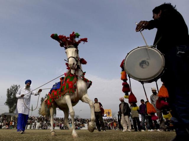 In this photo, a horse is made to dance to the rythm of a drum during a rural sports festival, also known as "Indian Rural Olympics", in Kila Raipur, near Ludhiana. The sports festival features major Punjabi rural sports including Bullock cart race, tug-of-war, tractor race and events for the disabled, among others. AP Photo/Altaf Qadri