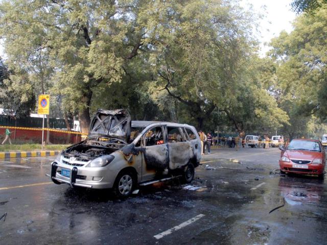 Forensic expert examining an Israel embassy car which caught fire after a blast in New Delhi.