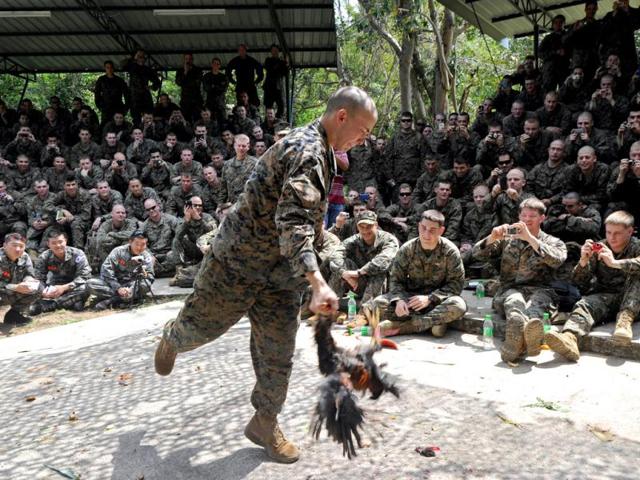 A US Marine holds a slaughtered chicken during a jungle survival program as part of the annual Cobra Gold 2012 combined military exercise at a naval base in Sattahip. AFP Photo/Pornchai Kittiwongsakul