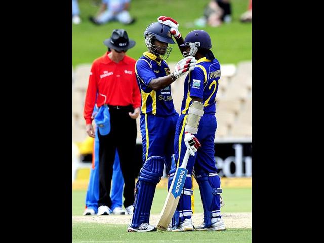 Sri Lanka's Dinesh Chandimal celebrates his 50 runs with teammate Mahela Jayawardene during their One Day International cricket match against India in Adelaide, Australia. AP Photo/David Mariuz
