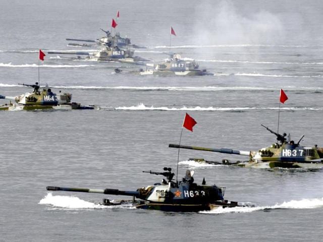 Amphibious tanks taking part in the Sino-Russia joint military exercise are seen in waters near eastern China's Shandong peninsula in this file photo. As looming budget cuts force the Pentagon to plan for a smaller US navy, China is accelerating the launch of new, increasingly capable warships as part of a sustained drive to become a major maritime power. Reuters/China Newsphoto/Files