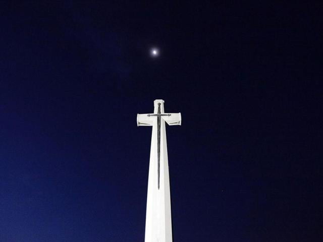 The moon is seen above a cross at the Kranji Commonwealth War Memorial Cemetery before an Australian memorial service in Singapore. The dawn service was held to commemorate the 70th anniversary of the fall of Singapore during World War II. Reuters/Tim Chong