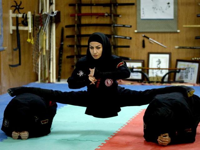 A Ninjutsu practitioner performs a split as members of various Ninjutsu schools showcase their skills to the media in a gym at Karaj. (Reuters/Caren Firouz)