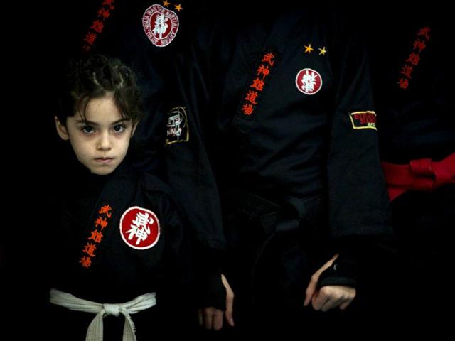 A young Ninjutsu practitioner stands beside fellow members of various Ninjutsu schools as they wait to showcase their skills to the media in a gym at Karaj. (Reuters/Caren Firouz)