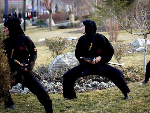 Ninjutsu practitioners participate in a sword drill as members of various Ninjutsu schools showcase their skills to the media at a park in Karaj. (Reuters/Caren Firouz)