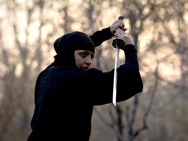 A Ninjutsu practitioner participates in a sword drill as members of various Ninjutsu schools showcase their skills to the media at a park in Karaj. (Reuters/Caren Firouz)