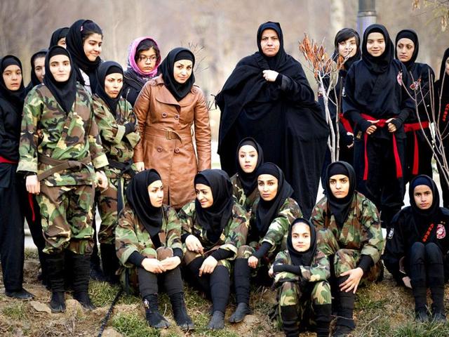 Parents, instructors and students watch drills performed by fellow members of various Ninjutsu schools at a park in Karaj. (Reuters/Caren Firouz)