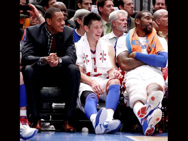 New York Knicks' Jeremy Lin (C) talks with teammates Carmelo Anthony (L) and Amare Stoudemire (R) during the second half of an NBA basketball game against the Sacramento Kings in New York. AP Photo/Frank Franklin II