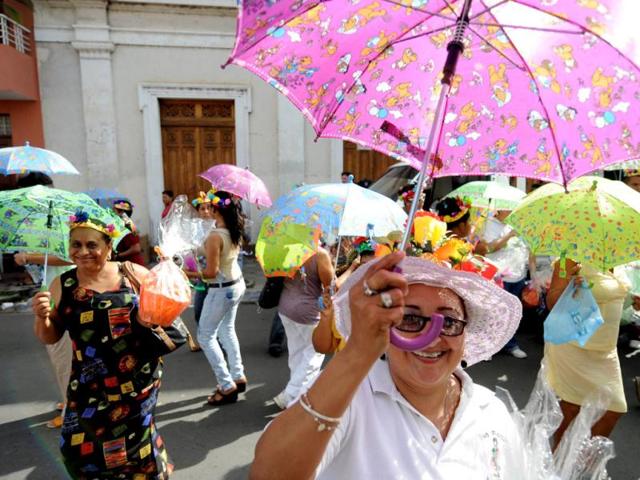 Nicaraguans with umbrellas take part in the ''Poetry Carnival'' during celebrations of the VIII International Poetry Festival in Granada, about 50 kms south of Managua. AFP Photo/ Elmer Martinez