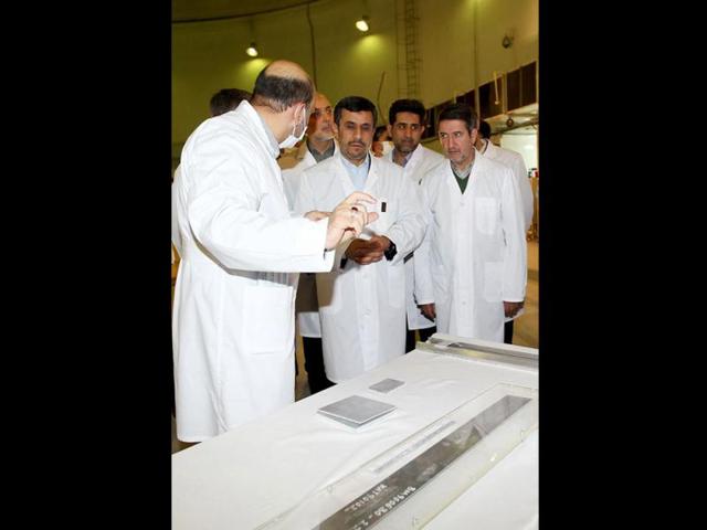 In this photo released by the Iranian President's Office, Iranian President Mahmoud Ahmadinejad, center is escorted by technicians during a tour of Tehran's research reactor centre in northern Tehran, Iran. (AP Photo/Iranian President's Office)