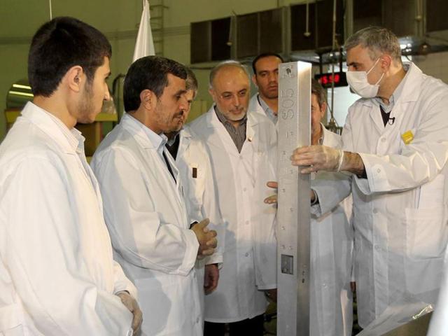 This photo released by the Iranian President's Office, claims to show Iranian President Mahmoud Ahmadinejad, second left being escorted by technicians during a tour of Tehran's research reactor centre in northern Tehran, Iran. (AP Photo/Iranian President's Office)