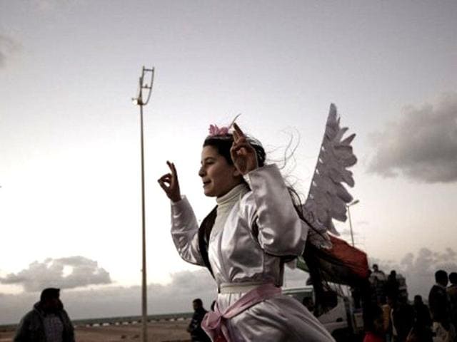 A Libyan girl dressed as an angels waves the victory sign in Benghazi - the cradle of revolt against Muammar Gaddafi - on the eve of the anniversary of the first protest against the slain dictator. AFP/Gianluigi Guercia