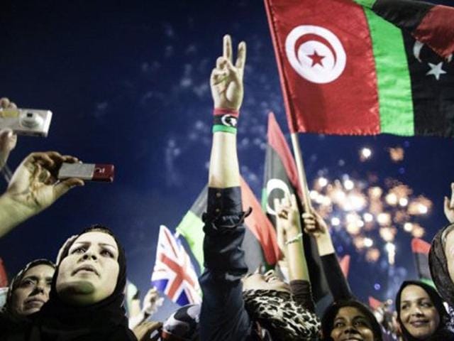Libyans celebrate following the announcement of the liberation of the country in Martyr's Square in central Tripoli on October 23, 2011 three days after ousted despot Muammar Gaddafi was captured and killed. AFP/Marco Longari, File