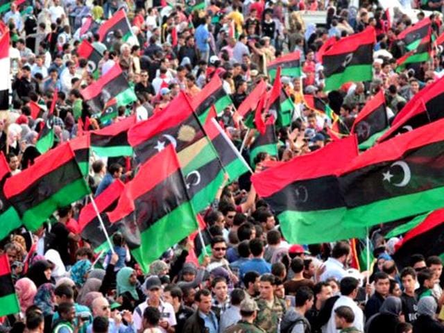 Libyans wave their new national flag as they celebrate following the official liberation of the country in the eastern city of Benghazi on October 23, 2011 three days after ousted despot Muammar Gaddafi was captured and killed. AFP/Abdullah Doma, File