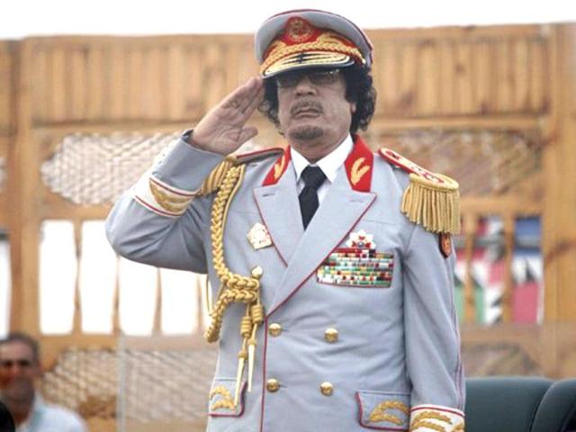 Libyan leader Muammar Gaddafi salutes during the 40th anniversary of the evacuation and expulsion of US forces and bases on Libyan soil. AFP/Mahmud Turkia, File