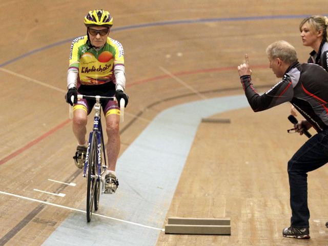 Trainer Robert Mistler (C) boosts cyclist Robert Marchand of France (L) next to trainer Magali Humbert-Perret during his attempt to set a world record for cycling non-stop for one hour, in the over 100-year-old category, at the Union Cycliste Internationale (UCI) velodrome in Aigle. Reuters/Denis Balibouse