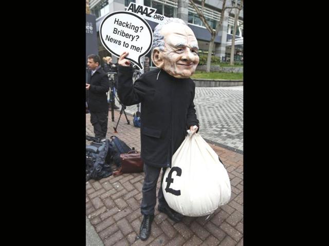 A protester wearing a mask depicting Rupert Murdoch, stages a protest against him, outside the headquarters of News International in London. AP/Lefteris Pitarakis