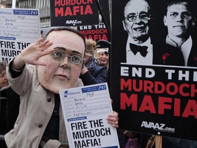 Demonstrators from the campaign group 'Avaaz' protest outside the Queen Elizabeth II centre in London, as BSkyB hold their annual general meeting. James Murdoch, son of News Corp chief Rupert Murdoch, is expected to face calls from shareholders to resign as chairman of BSkyB, amid continued allegations of phone hacking by News International publication The News of the World. AFP PHOTO/CARL COURT