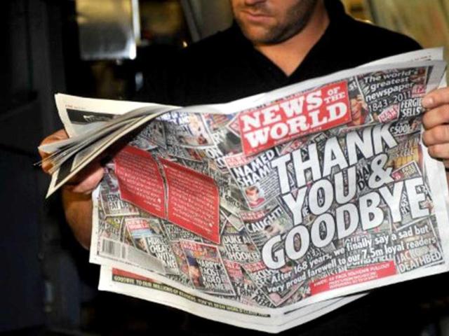 Printer James Bradley reads the final edition of the British tabloid newspaper News of the World as it rolls off the press at the News International print works in Waltham Cross, Hertfordshire. AFP Photo