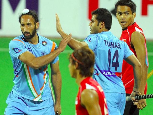 Tushar Khandker of India (C) congratulates teammate Sardar Singh after a goal during the men's field hockey match against Singapore of the FIH London 2012 Olympic Hockey qualifying tournament at the Major Dhyan Chand National Stadium in New Delhi. AFP/Prakash Singh