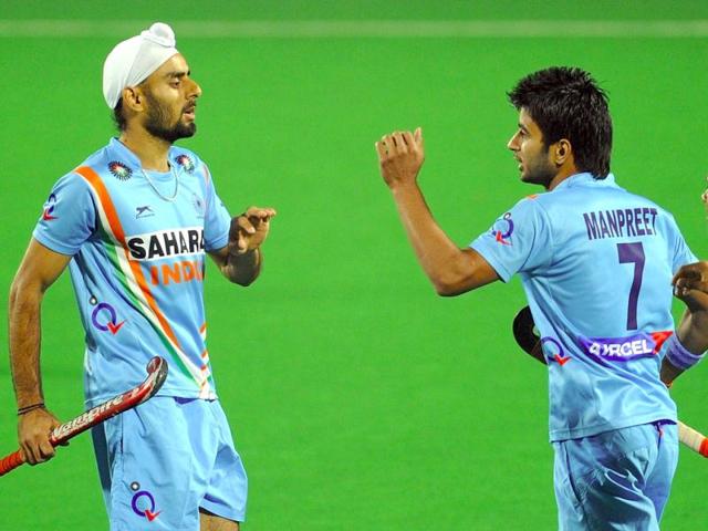 Gurwinder Singh Chandi (L) celebrates a goal against Singapore with teammate Manpreet Singh during the men's field hockey match of the FIH London 2012 Olympic Hockey qualifying tournament at the Major Dhyan Chand National Stadium in New Delhi. AFP/Prakash Singh