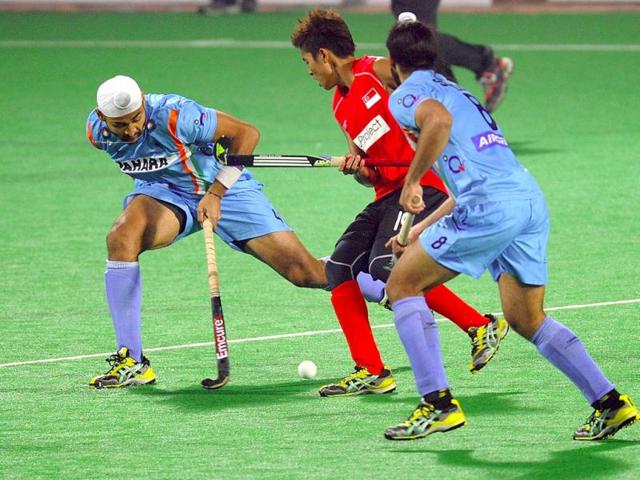 Sandeep Singh (L) and Sardar Singh block Muhammad Hidayat Mat Rahim of Singapore (C) during the men's field hockey match of the FIH London 2012 Olympic Hockey qualifying tournament at the Major Dhyan Chand National Stadium in New Delhi. AFP/ Prakash Singh