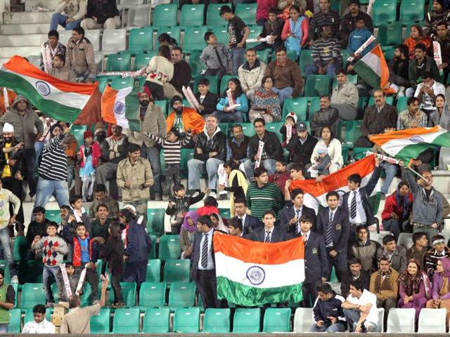 Fans wave the Tricolour during the London 2012 Olympic Games men's field hockey qualifying match between India and Singapore in New Delhi. India won by 15-1. Reuters photo