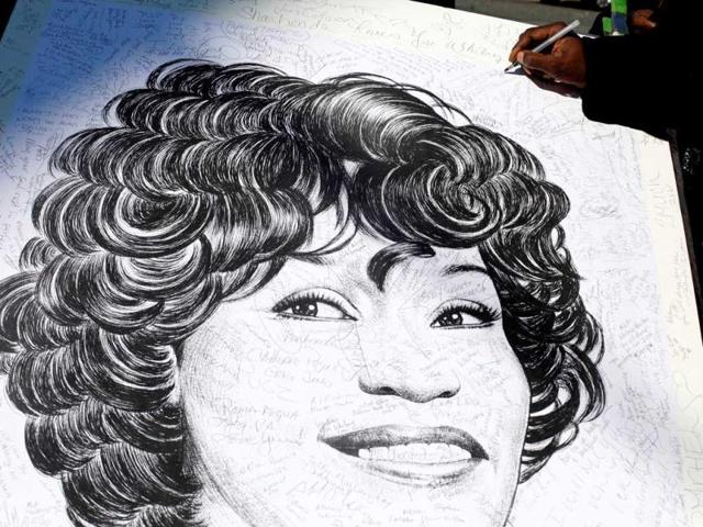 Fans sign artwork by artist Mark G at the funeral service for Whitney Houston in Newark, New Jersey. Whitney Houston was found dead in her hotel room at The Beverly Hilton hotel on February 11, 2012. Allison Joyce/Getty Images/AFP