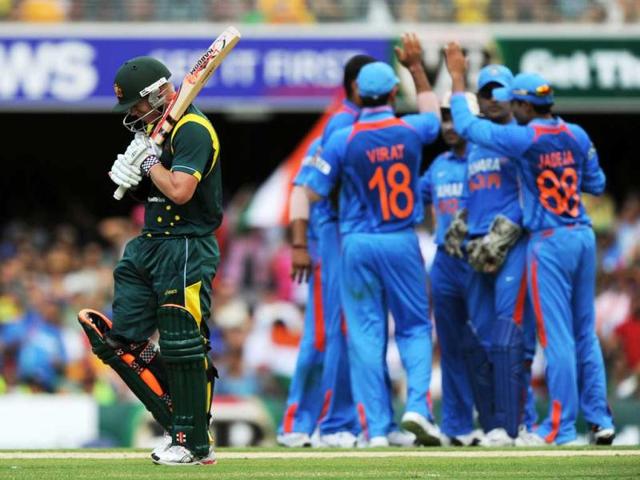 Indian players celebrate the dismissal of Australian batsman David Warner (L) during the one-day international cricket match in Brisbane. AFP Photo/Greg Wood