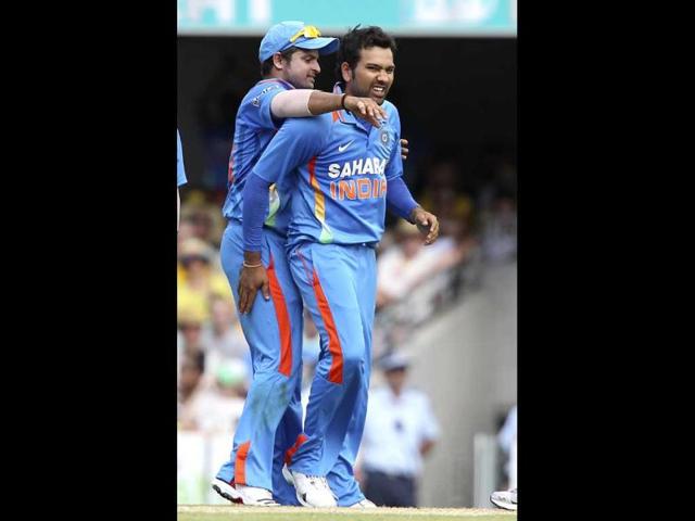 Suresh Raina, left, celebrates with Rohit Sharma, right, after Sharma got the wicket of Australia's Matthew Wade during the one-day international cricket match between Australia and India in Brisbane. AP Photo/Tertius Pickard