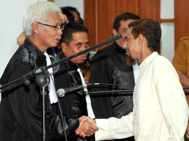 Indonesian Muslim militant and suspected Bali bomber Umar Patek (R) shakes hand with a prosecutor (L) after his trial in Jakarta. During the first hearing on February 13, 2012 prosecutors say they will push for death penalty for Patek, who is facing murder charges for the 2002 Bali bombing and five other counts, including bomb-making and illegal firearms possession. (AFP/Adek Berry)
