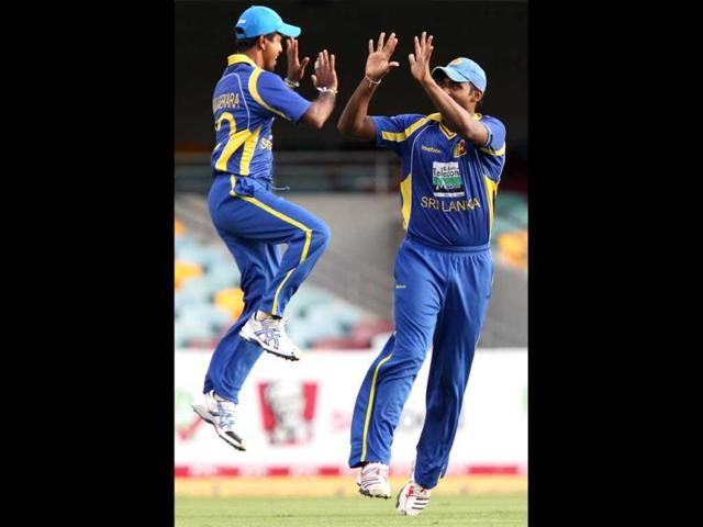 Sri Lanka's Nuwan Kulasekara, left, celebrates with teammate Thisara Perera after the wicket of Virender Sehwag during their One Day International cricket match in Brisbane. AP Photo/Tertius Pickard