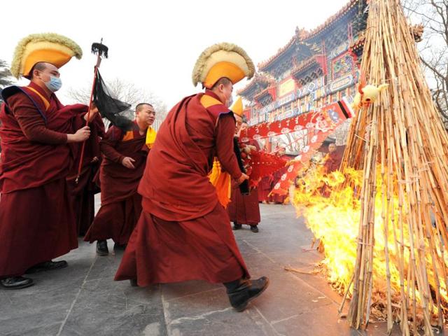 Tibetan monks throw a skull effigy into flames during a Tibetan New Year ceremony at the Yonghe Temple, also known as the Lama Temple in Beijing. AFP Photo/Mark Ralston