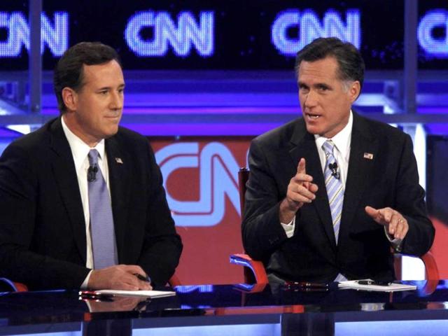 US Republican presidential candidate former US Senator Rick Santorum listens as former Massachusetts governor Mitt Romney (R) speaks during the Republican presidential candidates debate in Mesa, Arizona. Reuters/Joshua Lott